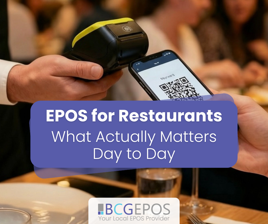 Restaurant staff using EPOS system with handheld device and kitchen display screens during busy service in a modern dining environment.